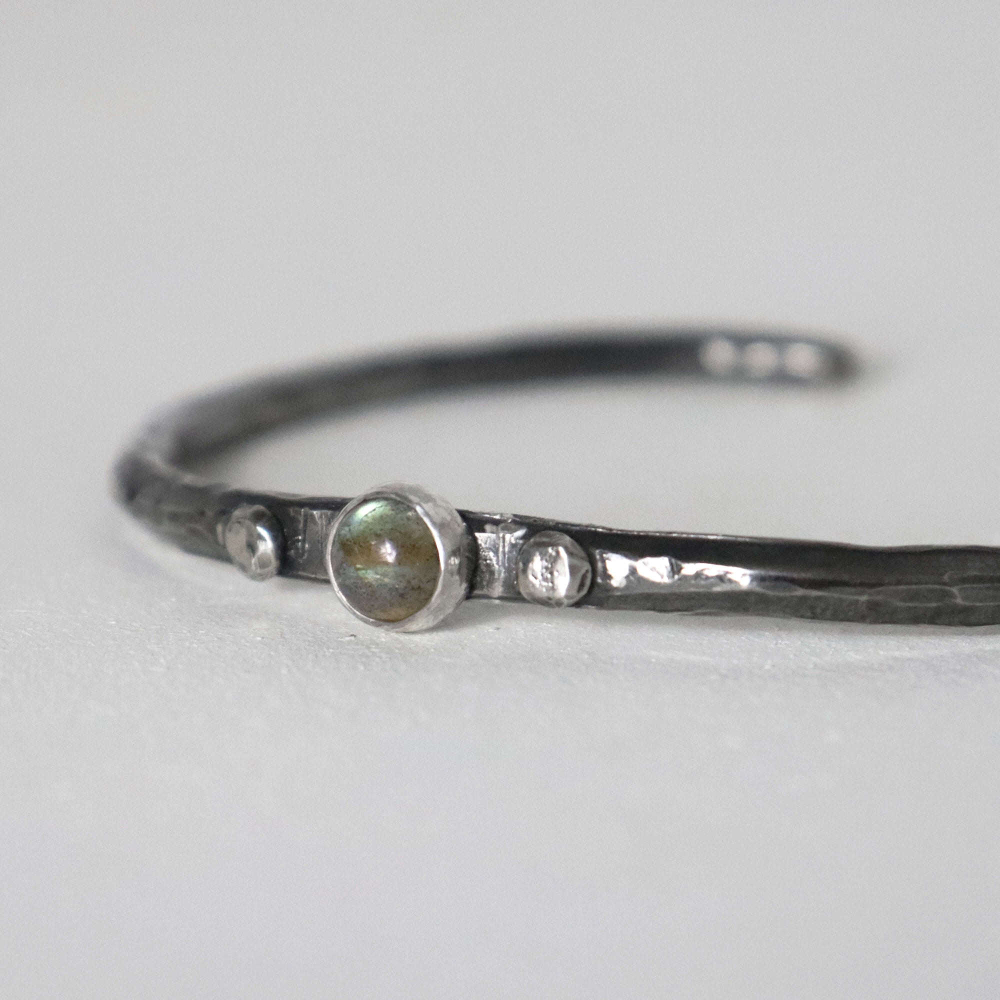 Open sterling silver cuff bracelet with hammered texture and dark oxidised finish