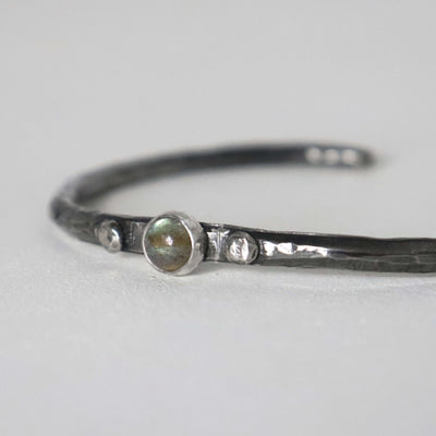 Open sterling silver cuff bracelet with hammered texture and dark oxidised finish