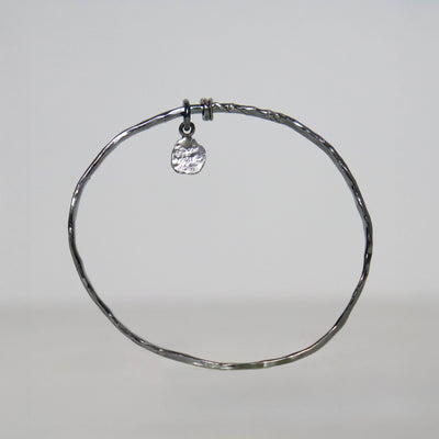 Roff Jewellery handmade sterling silver bangle with hammered oxidized surface, two loose rings and a small stamped silver charm.