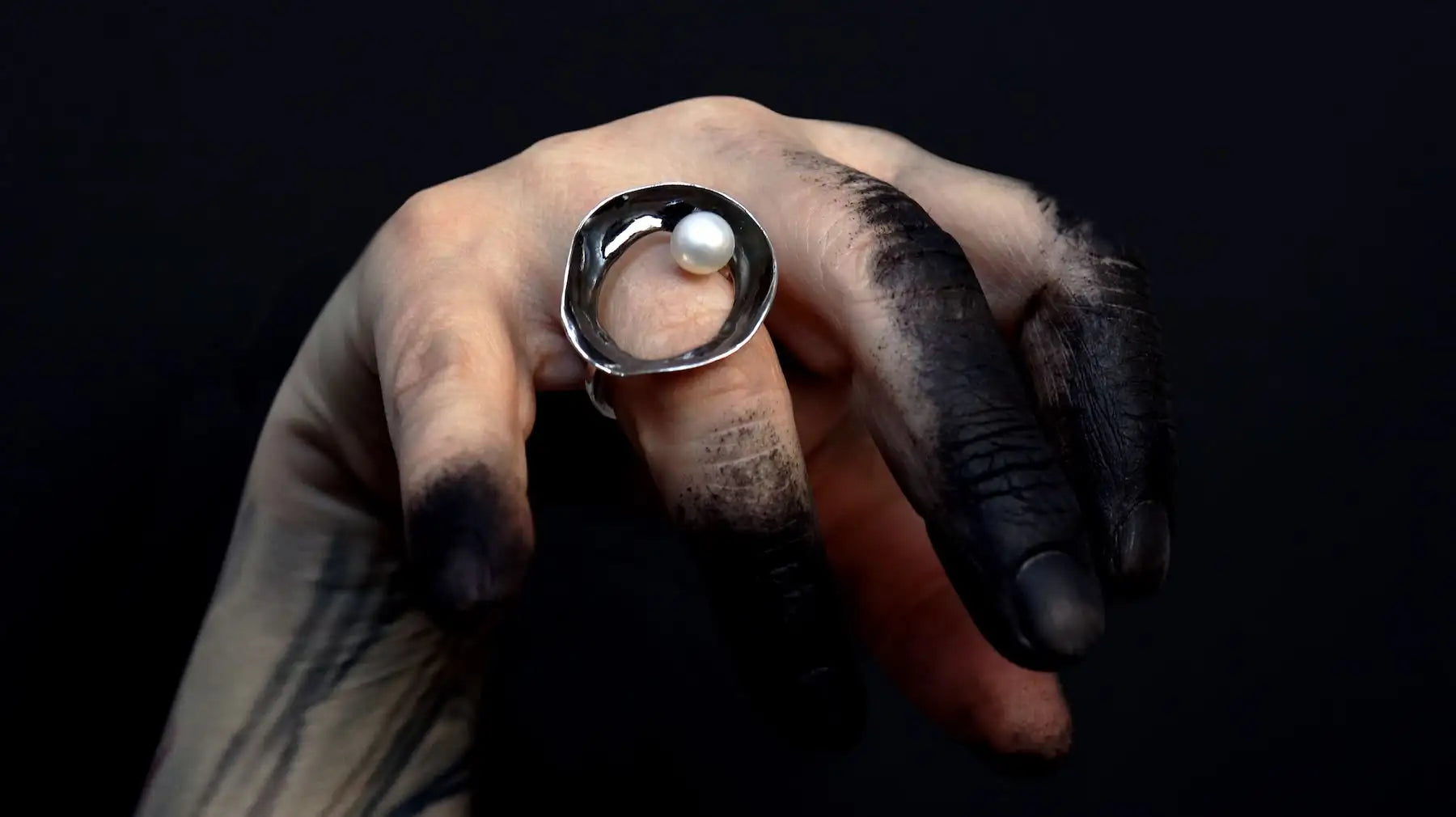 Silver ring in circular shape with a natural pearl set on one side