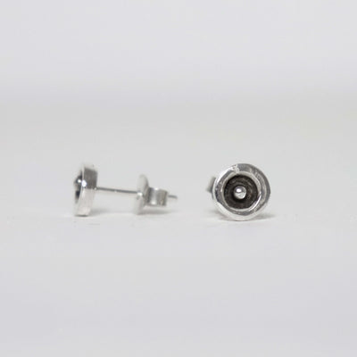 Small 7 mm sterling silver stud earrings featuring a raised silver dot inside a polished circular rim with a blackened centre