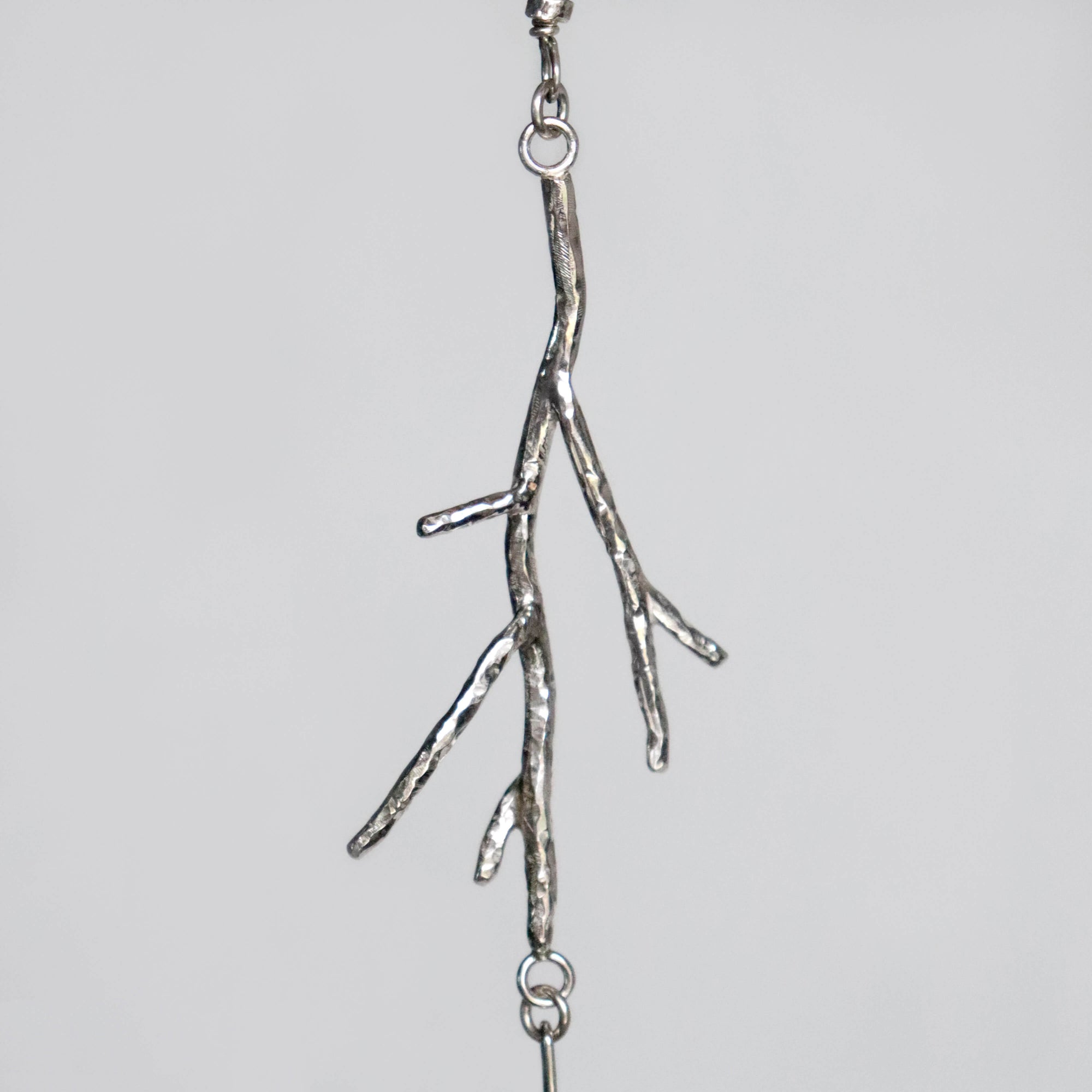 silver twig shaped pendant on statement necklace. handforged by roff jewellery
