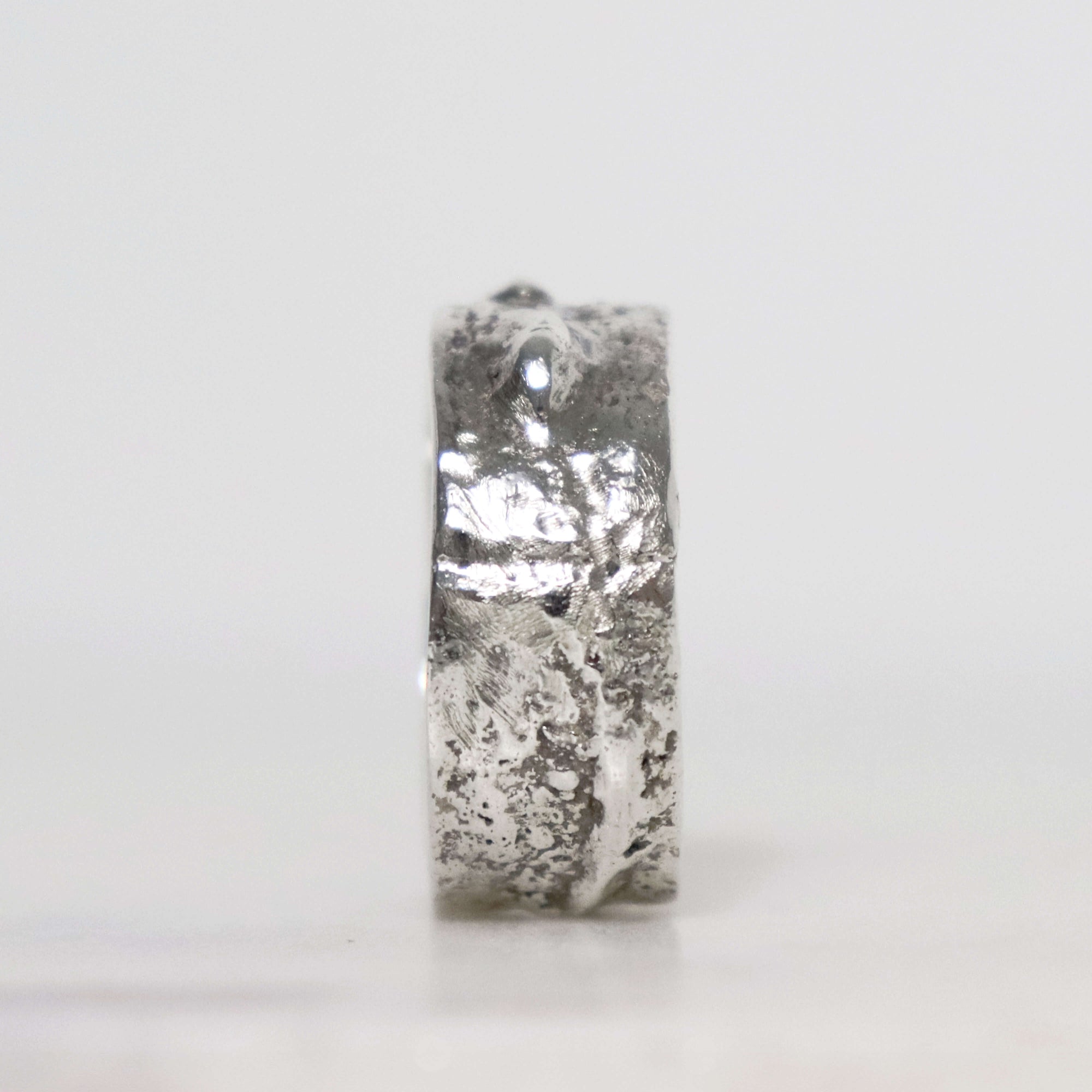 Wide men's sterling silver ring with irregular fused metal texture, polished silver patches and dark oxidized recesses