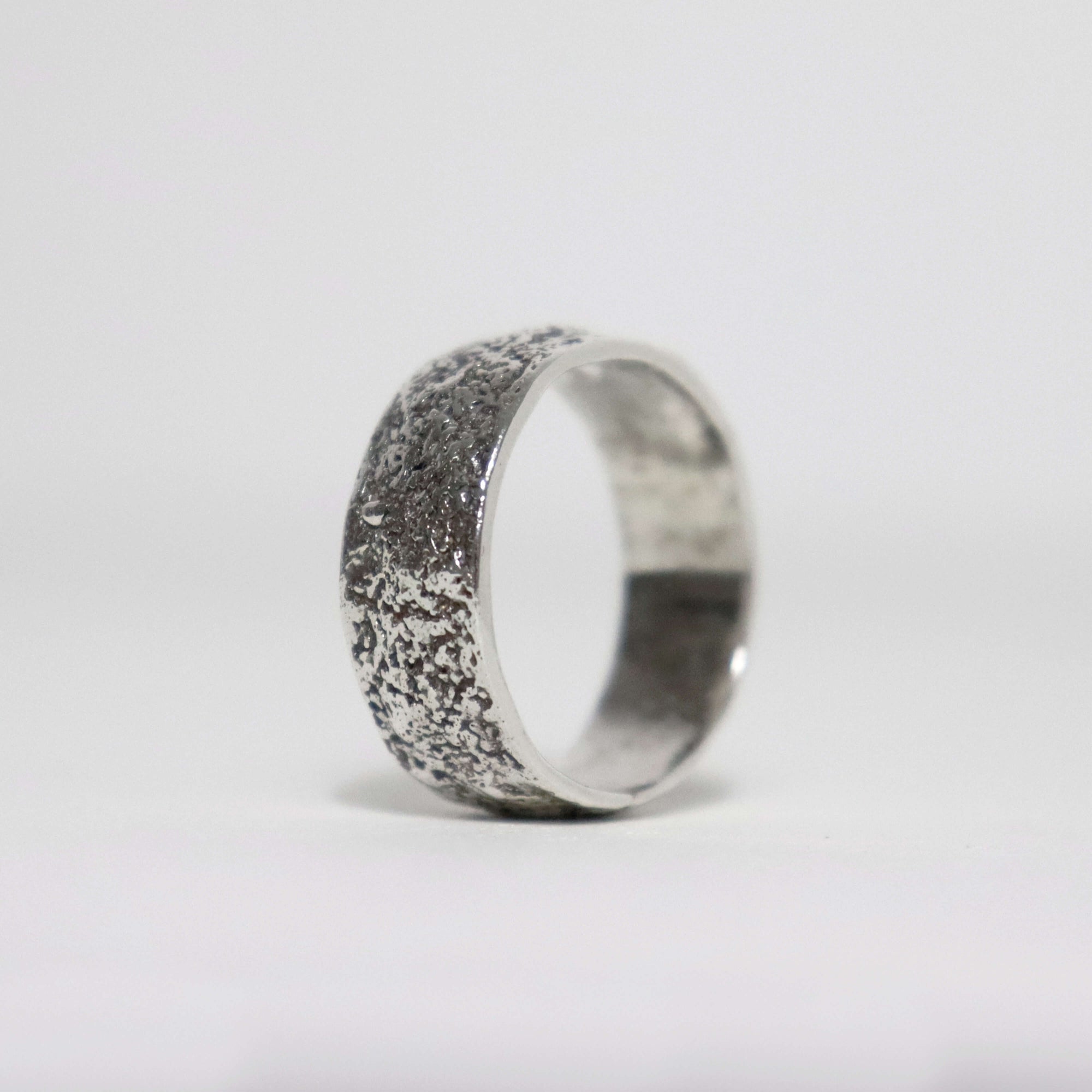 Handmade textured sterling silver men's ring with fused silver sawdust surface, oxidized finish and polished interior.