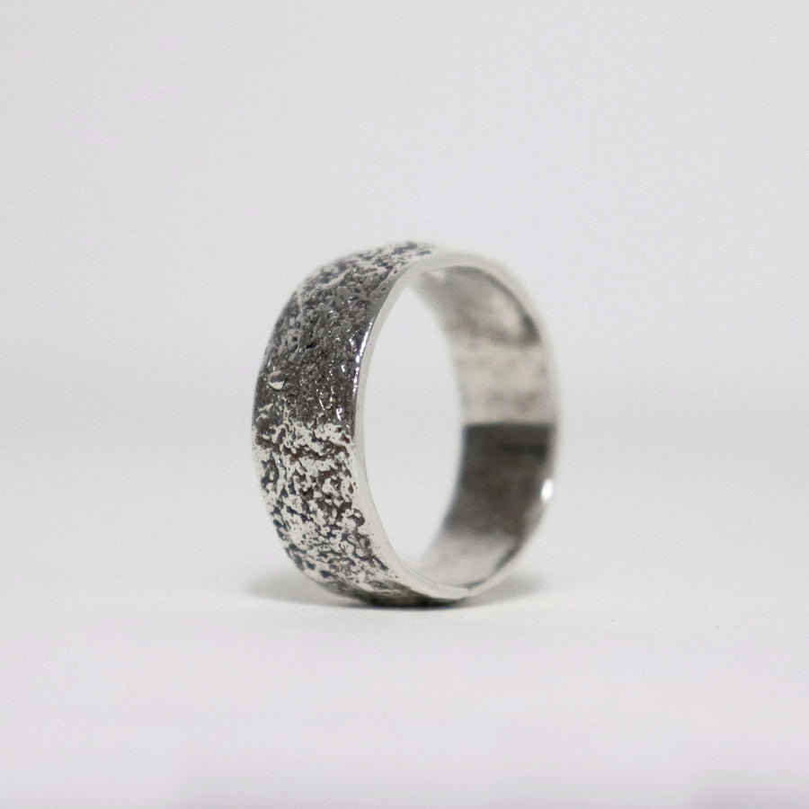Handmade textured sterling silver men's ring with fused silver sawdust surface, oxidized finish and polished interior.
