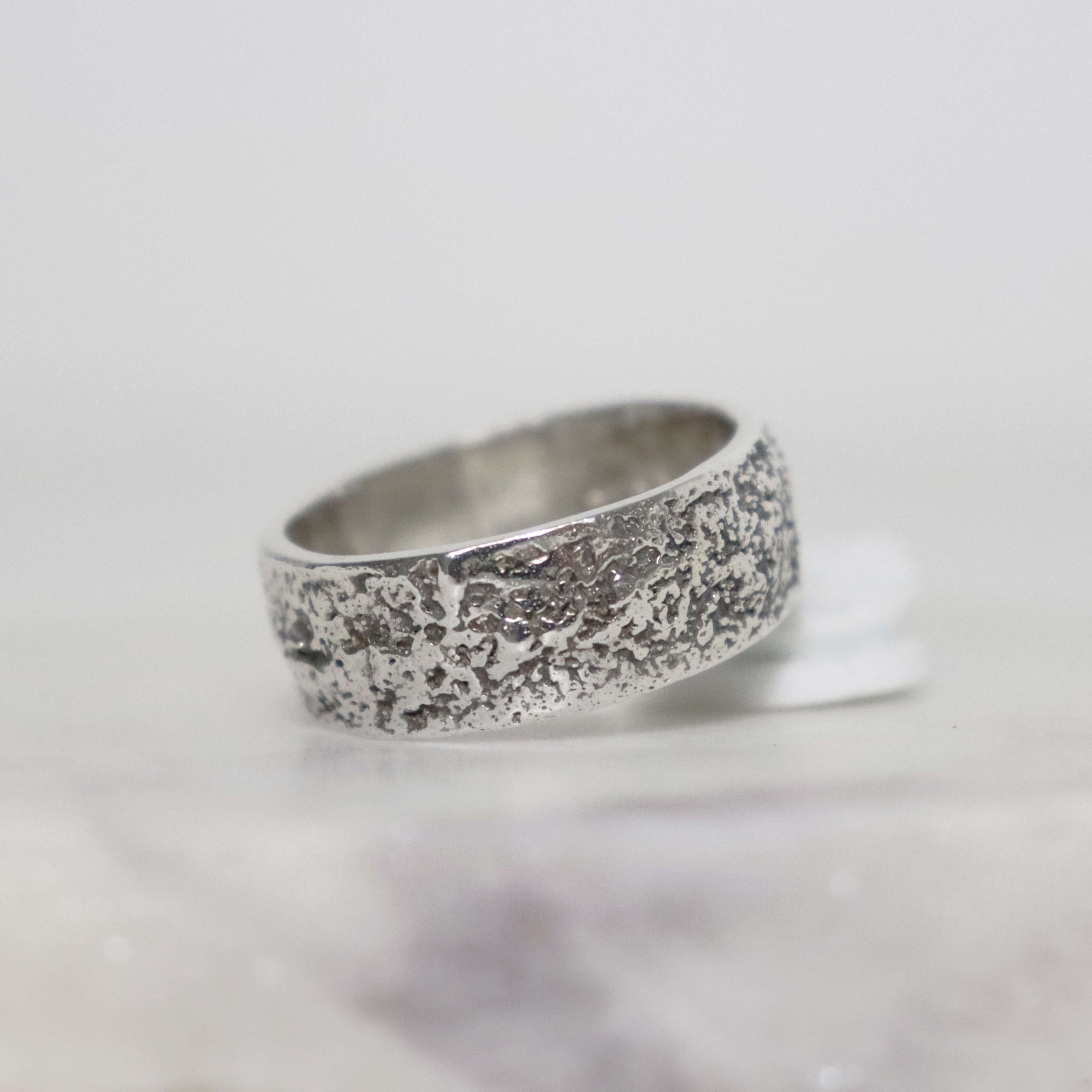 Wide 8 mm sterling silver men's ring with distinctive stardust texture, dark oxidized details and polished silver edges