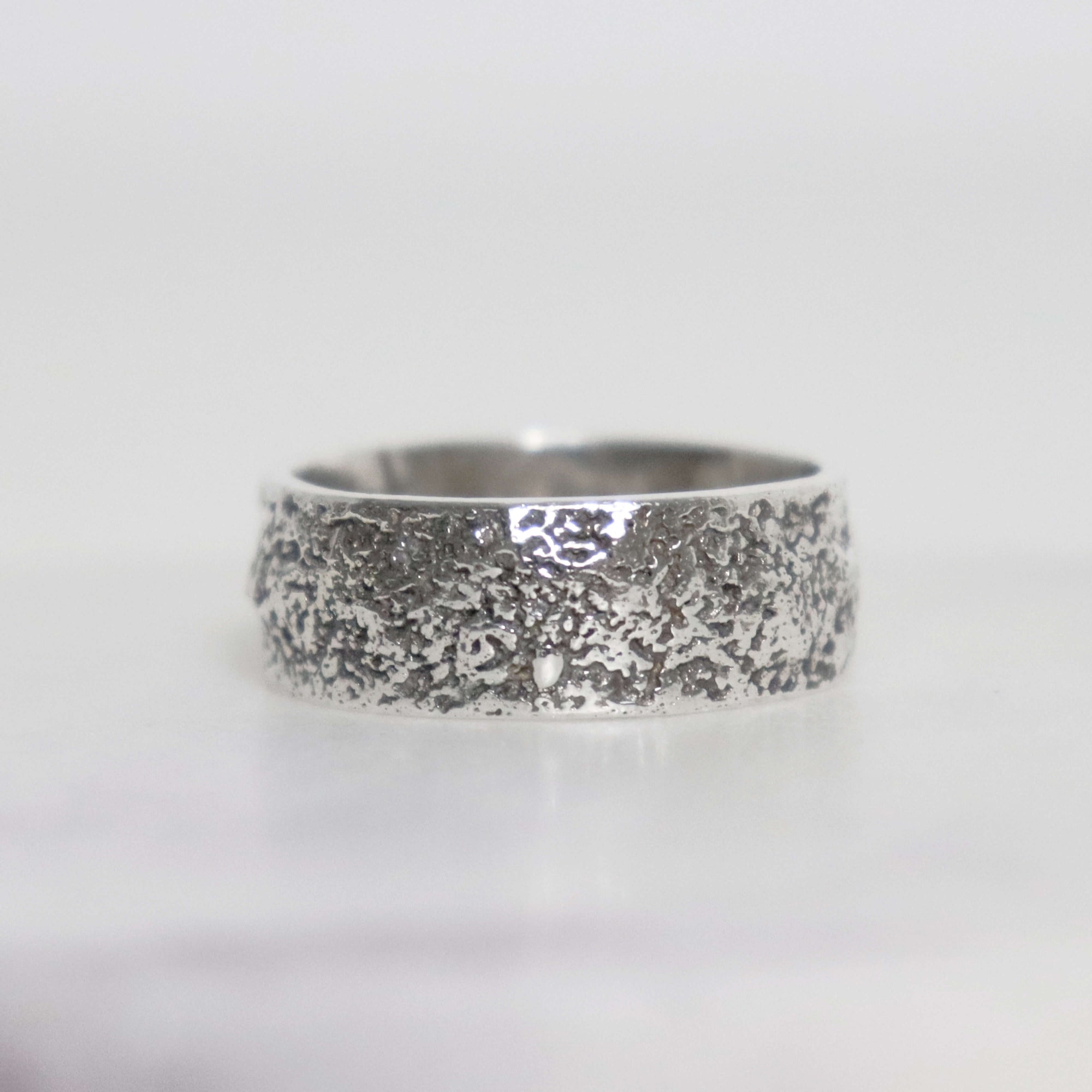 Handmade sterling silver men's ring with unique fused silver sawdust texture, wide oxidized band and polished silver interior.