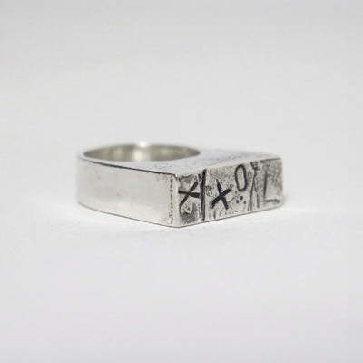 One of a kind sterling silver signet ring with hand-stamped XXO pattern, oxidised details and silver sawdust texture.