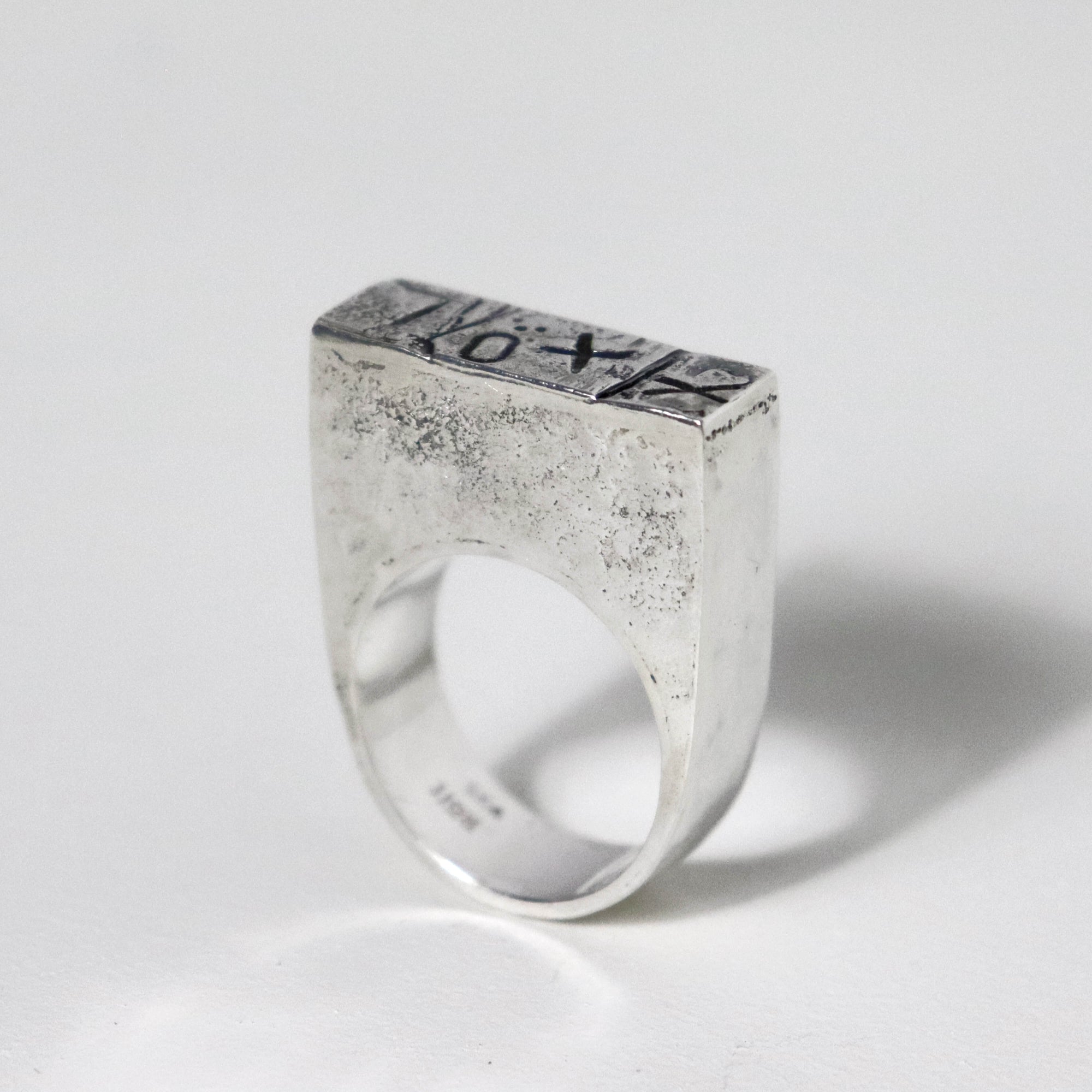 Handmade sculptural sterling silver statement ring with bold XXO markings, wide silver band and architectural design.