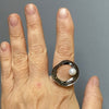 ladies hand showing a black oxidized silver retro sixties ring with white peal by roff jewellery