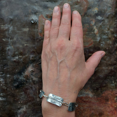 silver plate bracelet on a womens wrist, dark patina textured silver bracelet, handmade by roff