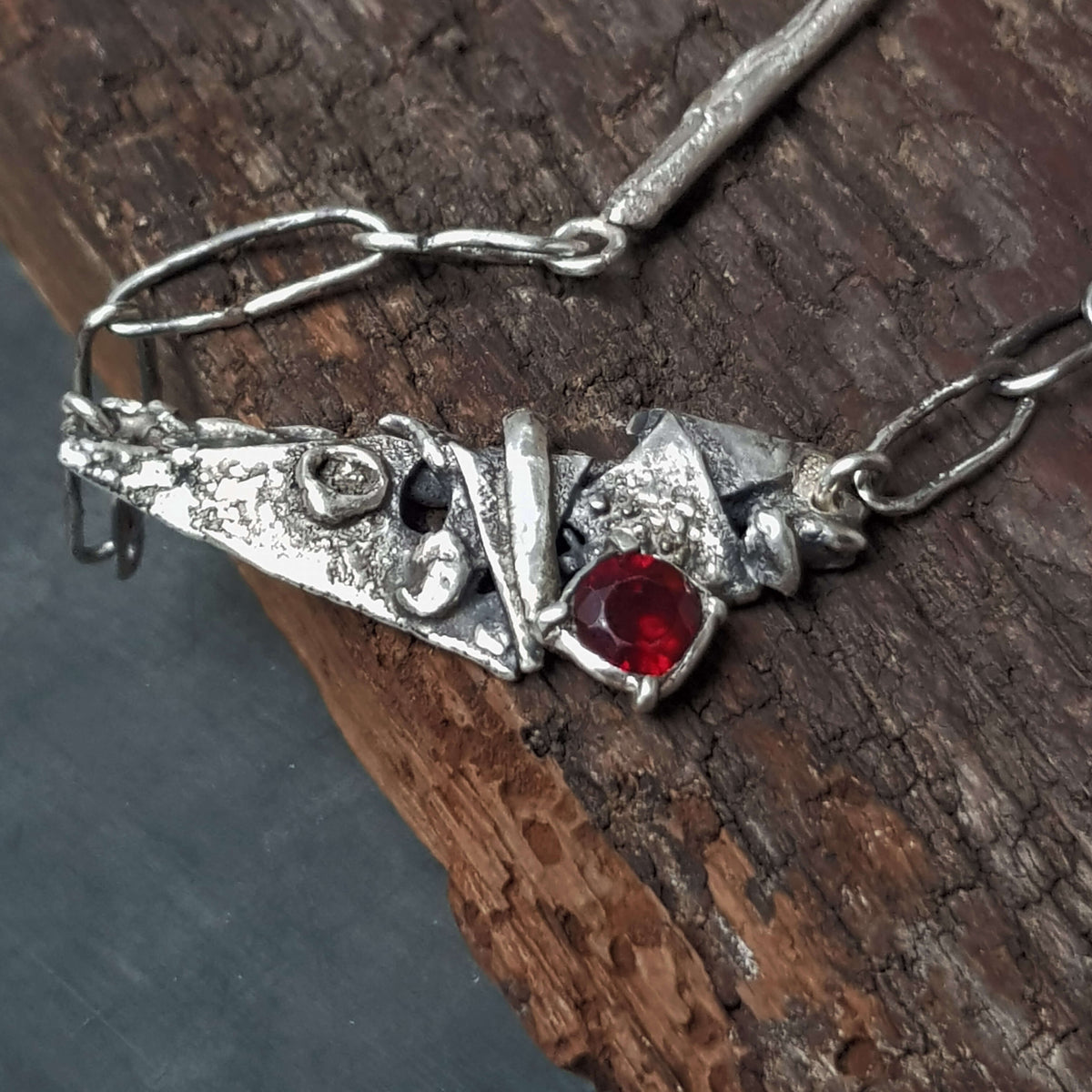 oxidized silver necklace, artisan made, all handmade silver links and a red faceted garnet set in the silver pendant