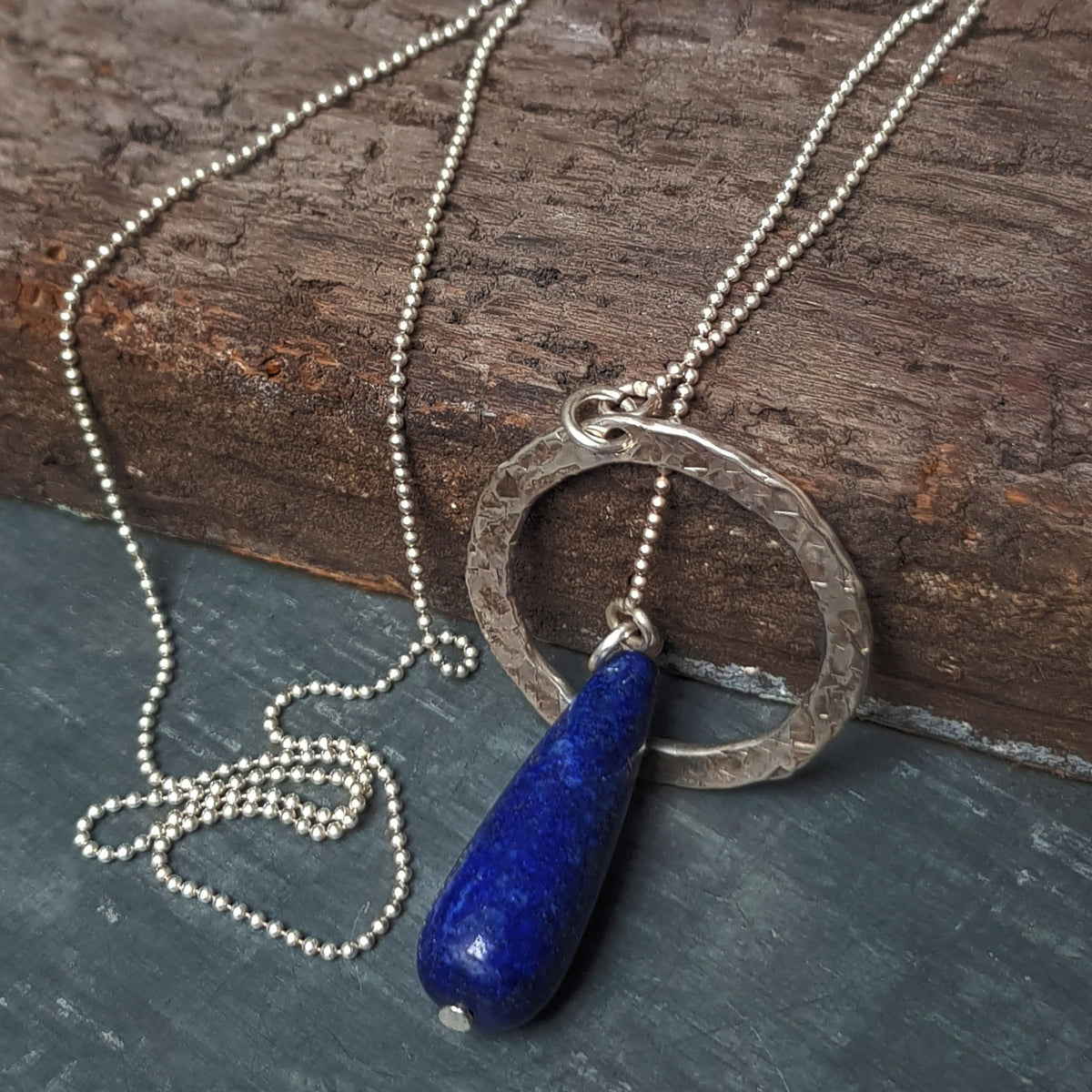 Handmade unique rough silver circle pendant on a silver necklace with lapis lazuli by roff jewellery