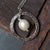 rough hammered round silver necklace with a white fresh water pearl on silver chain.handmade by roff