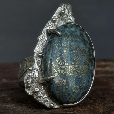 blue and gold stone set with claws and smooth bezel on textured silver ring, handmade by roff